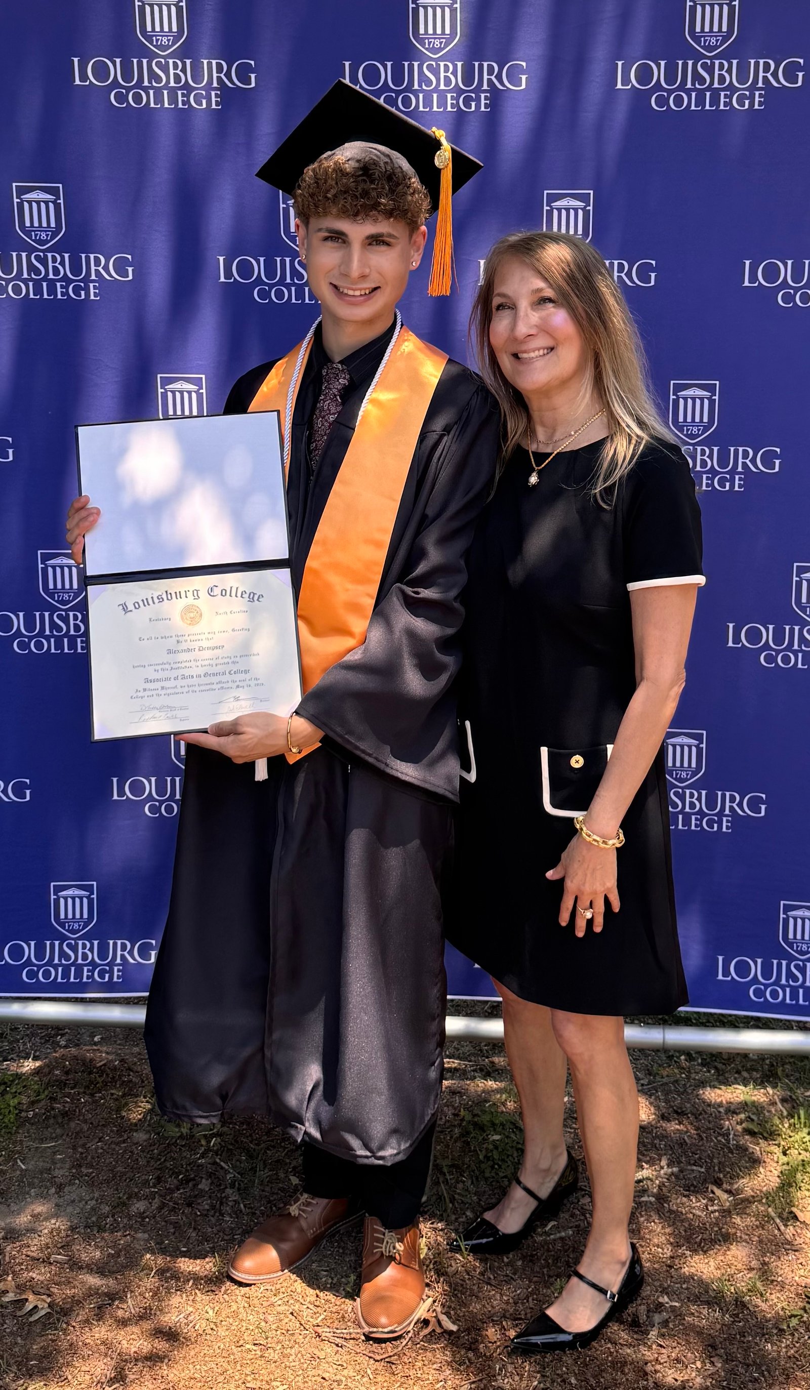 Kim and Alexander Dempsey at Louisburg College graduation, holding Alexander's diploma